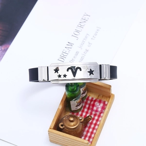 Dettaglio macro del segno zodiacale Ariete su bracciale in silicone nero e metallo