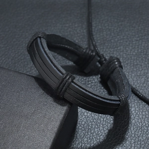 Bracelet multicouche en cuir tressé noir pour homme présenté sur une boîte d'exposition