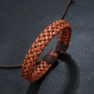Vintage braided brown leather bracelet for men with adjustable cord on black background