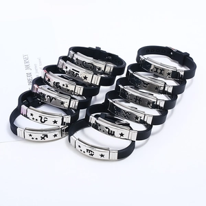 Bracciali zodiacali in silicone nero con simboli in acciaio inossidabile su sfondo bianco
