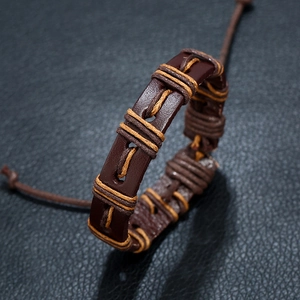 Retro punk woven brown leather bracelet with adjustable cords on a dark textured background