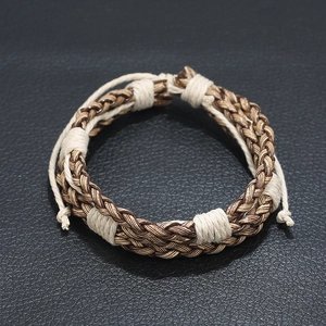 Vintage woven leather bracelet for men with brown braided cord on black background