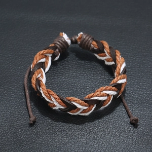 Handcrafted vintage woven leather bracelet with adjustable cord on black texture