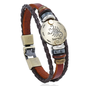 Detail of multi-layer leather Scorpio bracelet with vintage metal plate and beads