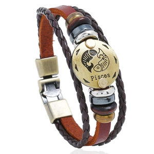 Detailed shot of retro braided leather bracelet featuring bronze Pisces zodiac emblem