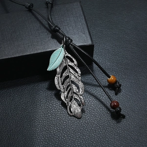 Sautoir ethnique rétro avec pendentif plume argentée et cordon tressé noir ajustable