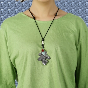 Vintage long leaf pendant necklace with red bead and adjustable black cord on model