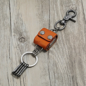 Retro punk genuine leather keychain with spring hook and rings on wooden surface
