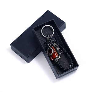 Braided leather keychain set with silver hardware inside a black textured gift box