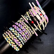 Detail of colorful reflective braided bracelets showing textures and heart charms