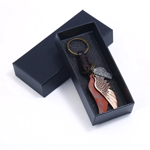 Vintage wing keychain with bronze feathers and leather cord in a premium black gift box