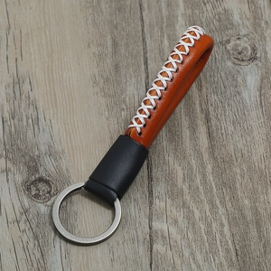 Retro brown leather keychain with white cross-stitch detail and silver metal ring