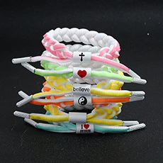 Close-up of multicolored braided rope bracelets with believe and I heart Jesus engravings