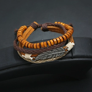 Vintage multilayer leather bracelet with wooden beads and silver leaf charm on a stand