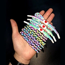 Close-up of holographic reflective braided bracelets with heart-shaped clasps