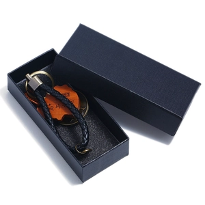 Braided leather keychain set with antique coin and wooden charm in a black gift box