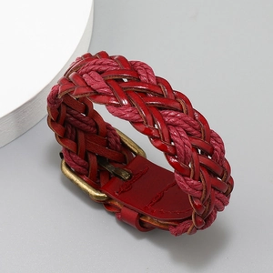 Detailed close-up of handmade red braided leather bracelet with vintage brass metal buckle