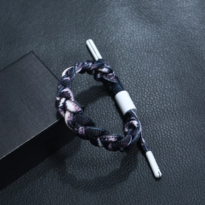 Macro detail of multi-layer woven braided bracelet with marble pattern on black leather