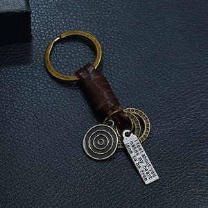 Retro handmade braided brown leather keychain with bronze ring and vintage metal charms