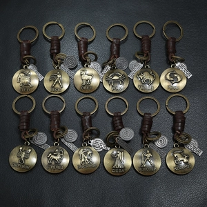 Retro woven leather keychain set with bronze 12 zodiac pendants on black background
