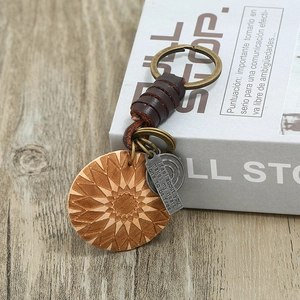 Vintage braided leather keychain with geometric engraved wood pendant on rustic book