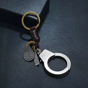 Vintage handcuff keychain with brown leather wrap and engraved quote on black leather