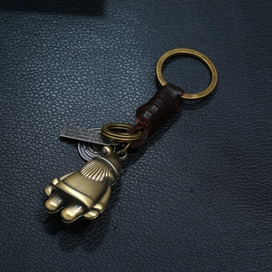 Handcrafted vintage leather keychain with bronze metal ring and engraved charm on black leather