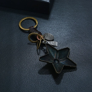 Porte-clés étoile en cuir vintage fait main avec pendentif sur fond de cuir noir