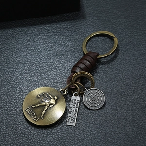 Macro shot of Libra zodiac keychain with bronze plaque, leather wrap and silver charm