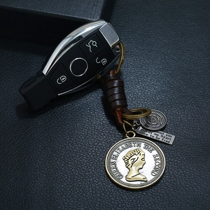 Handmade woven leather keychain with vintage Queen Elizabeth coin and metal charms