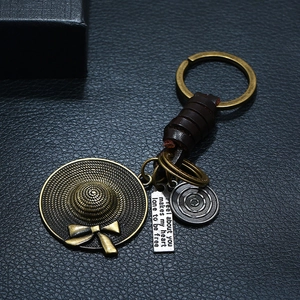 Porte-clés rétro en cuir avec chapeau en bronze et plaque gravée sur fond de cuir noir