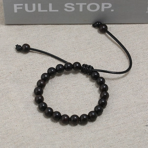 Naturholz Armband aus dunklem Ebenholz mit verstellbarer schwarzer Kordel auf Leinen