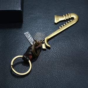 Retro saxophone keychain with woven leather strap and engraved metal plate on black background