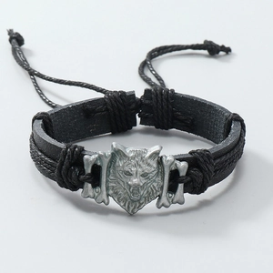 Detail of braided leather punk bracelet with silver wolf head and adjustable cord