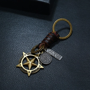 Retro braided leather keychain with bronze star pendant and engraved tags on dark leather