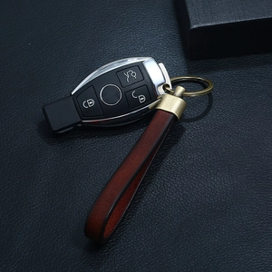 Detail of dark brown leather keychain strap with vintage metal buckle and car key fob