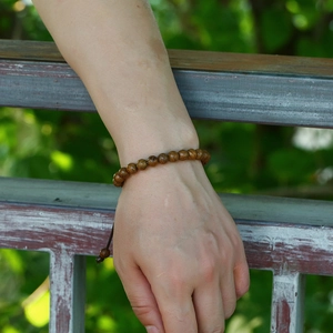 Nahaufnahme eines handgefertigten Armbands aus dunklem Naturholz mit markanter Maserung