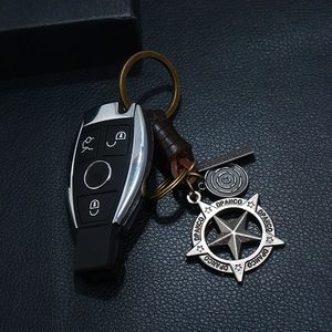 Close-up of woven leather keychain with vintage star pendant and key cover