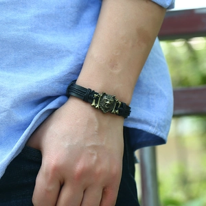 Retro braided leather bracelet featuring a bronze wolf head and bone charms for men