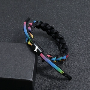 Macro shot of a braided zodiac bracelet with a rainbow gradient and Capricorn symbol