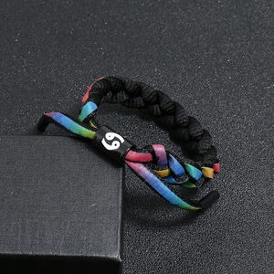 Macro shot of Cancer zodiac symbol on a colorful braided shoelace bracelet in a gift box