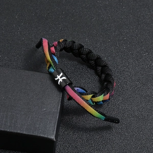 Detailed close-up of rainbow braided shoelace bracelet with black metal sliding cylinder