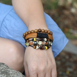 Retro braided leather bracelet set with wooden beads and turquoise accents on wrist