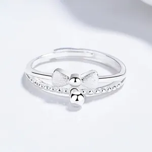 Detail of 925 silver double layer ring with frosted bow and polished bead pendant