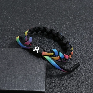 Macro shot of rainbow woven shoelace bracelet on a black gift box with adjustable clasp