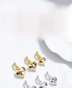 Macro shot of S925 silver heart pendants with unique hammered texture in gold and silver