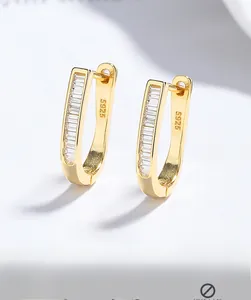 Gros plan de boucles d'oreilles en argent S925 doré avec zircons à coupe baguette