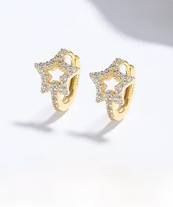 Macro shot of 925 silver hollow star earrings with gold plating and paved zircon stones