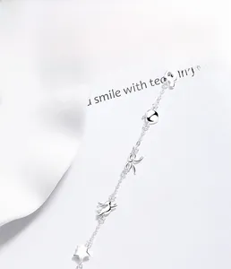 Gros plan du bracelet en argent sterling S925 avec breloques étoile, nœud et note