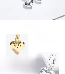 Detail view of heart-shaped S925 silver pendants in polished gold and silver finishes